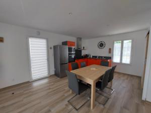 拉康提内勒A bâbord : maison chaleureuse à 300m de la plage的厨房以及带木桌和椅子的用餐室。