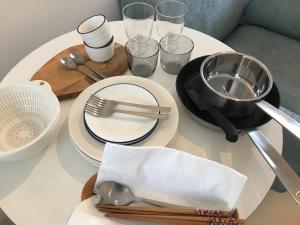 东京Oku-Shibu Residence的一张带盘子和餐具的白色桌子
