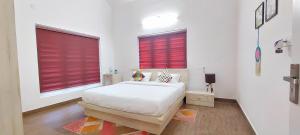苏丹巴特利ROBUSTA FOREST Home stay的一间白色卧室,在两个窗户上配有红色百叶窗