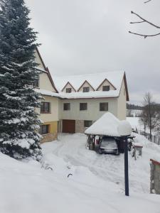 SkawaPokoje u Jasia i Małgosi的车道上一辆汽车停放在雪盖的房子里