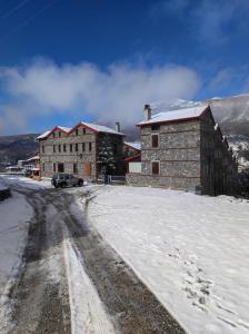 帕雷斯阿吉萨那Cozy Mountain Villa in P. Agios Athanasios的雪地里的一座建筑,旁边停着一辆汽车