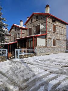 帕雷斯阿吉萨那Cozy Mountain Villa in P. Agios Athanasios的前面的地面上积雪的建筑