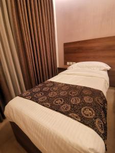 Umm UthainahDara apartment hotel的一间卧室配有一张带棕色和白色毯子的床