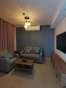 Umm UthainahDara apartment hotel的客厅配有两张沙发和一张桌子