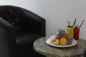 迪巴Mirage Hotel的椅子旁边的桌子上放着一盘水果
