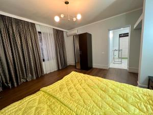 苏呼米S&M Village的一间卧室配有一张带黄色床罩的大床