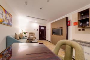 吉达Al Ertiqaa Hotel的客厅配有桌子和沙发