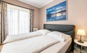 沃尔特湖畔佩莎赫奥尔迈尔公寓的卧室配有一张大白色床和窗户