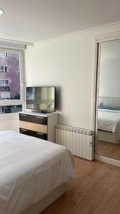 维戈Alojamiento Pichi的白色卧室配有床和镜子