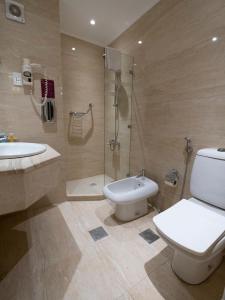 安曼安曼西部酒店的浴室配有卫生间、盥洗盆和淋浴。