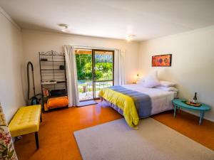塔卡卡Bay Cottage - Takaka Holiday Unit的一间卧室配有一张床、一张桌子和一个窗户。