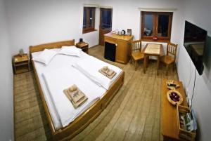 伯伊莱图什纳德Casa de oaspeti Kinga's Crown的卧室配有一张白色的大床和一张桌子
