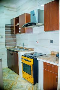 拉各斯Superb 2-Bedroom Duplex FAST WiFi+24Hrs Power的厨房配有黄色炉灶和水槽
