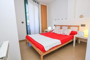 坎布里尔斯Ciutadella Litoral - ONLY FAMILIES的一间卧室配有红色和白色床单