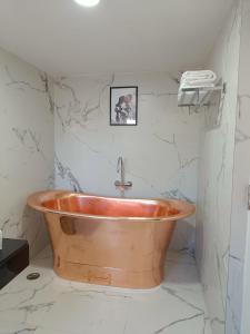 乌提Two Seas Residence的浴室设有大理石墙壁和铜质浴缸。