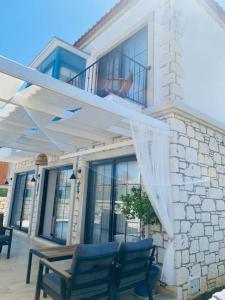 阿拉恰特Detached villa in Alaçatı…的房屋设有2把蓝色椅子和阳台
