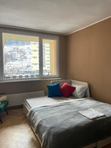 代温Апартамент Родопско мече的一间卧室配有带色彩缤纷枕头的床。