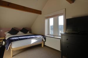 哈德斯菲尔德Lovely 4 Bed House in Huddersfield with parking的一间卧室配有床、窗户和梳妆台