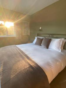 WeobleyMarshpools Bed & Breakfast - Licensed near Weobley village的卧室内的一张带白色床单和枕头的大床
