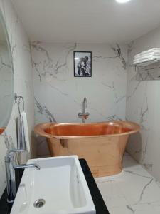 乌提Two Seas Residence的浴室配有木制浴缸和水槽