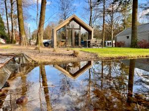 阿纳姆Holiday Home Maridu Forest的水坑里房屋的反射