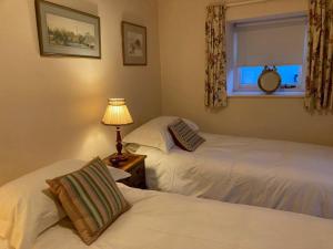 巴维特雷西Little Reeds的卧室设有两张床、窗户和一盏灯