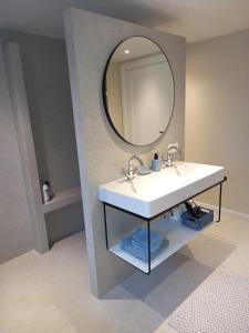 博克斯梅尔B&B Huize Placida的浴室设有白色水槽和镜子