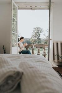 RanstBleyckhof in een uniek natuurgebied的坐在门前椅子上的女人