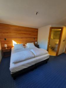 拉斯特朗卡斯Las Bravas Lodge的卧室配有一张白色大床和木制床头板