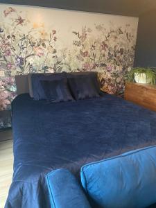 海伦芬BzB Jantina的一间卧室配有一张蓝色的床和花卉墙