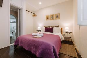 奥比多斯Casa António Moreira的一间卧室配有一张大床和紫色毯子