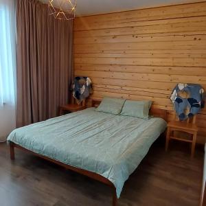 KocēniLauviņu rezidence的一间卧室配有一张木墙床