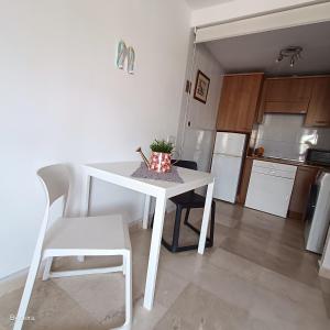 卡勒达德福斯特Apartment Las Arenas - Las Casas de Aron的厨房配有白色桌子和白色椅子