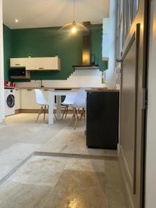 第戎Le loft Rousseau的厨房配有桌椅和绿色的墙壁