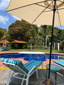 金巴亚Casa Lemar的游泳池旁的一对椅子和一把遮阳伞