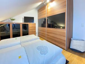 伯布林根4 Zimmer Apartment, 125 qm, ruhig und zentrumsnah, max 5 Pers, Dachterasse, Garage, 1000 MBit的卧室配有一张白色大床和电视。