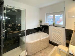 伯布林根4 Zimmer Apartment, 125 qm, ruhig und zentrumsnah, max 5 Pers, Dachterasse, Garage, 1000 MBit的带浴缸和玻璃淋浴间的浴室。