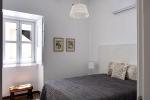 塔维拉Apartamentos do Rio的白色的卧室设有床和窗户