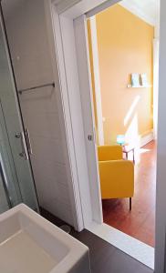 阿威罗阿维罗罗西奥旅舍的一间带水槽和黄色椅子的浴室