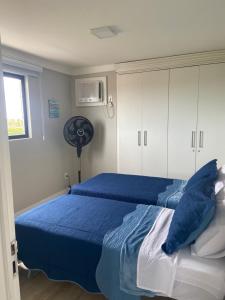 圣路易斯Ap Cozy Calhau prox PRAIA的一间卧室配有2张蓝色的床和风扇