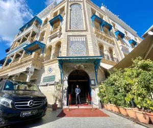 突尼斯Royal Victoria - Ex British Embassy的站在建筑物门口的人