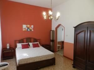 塔维亚诺Casa a Corte nel centro storico的一间卧室配有橙色墙壁的床