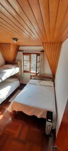 坎波斯杜若尔当Apartamento em Campos do Jordão próximo ao Capivari的配有木天花板的客房内的两张床