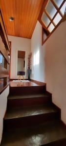 坎波斯杜若尔当Apartamento em Campos do Jordão próximo ao Capivari的客房设有楼梯、电视和窗户。