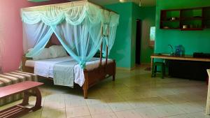 迪亚尼海滩Armaan Guest House的一间卧室配有一张天蓬床和一张书桌