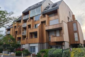 拉罗谢尔Superbe appartement cosy - Plage des minimes的公寓大楼拥有木质外墙