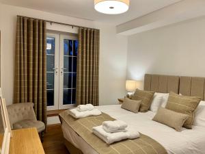 多诺赫Royal Golf Apartments的一间卧室配有带毛巾的床