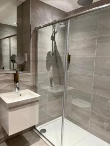 多诺赫Royal Golf Apartments的带淋浴、水槽和卫生间的浴室