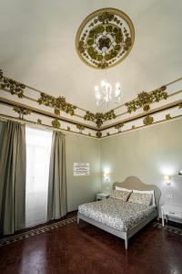 锡拉库扎Gli specchi di Archimede的一间卧室配有一张床和一个吊灯