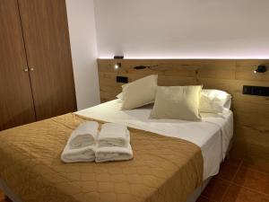 卡莱利亚德帕拉弗鲁赫尔BRISA DE CALELLA DE PALAFRUGELL的一间卧室配有一张床,上面有两条毛巾